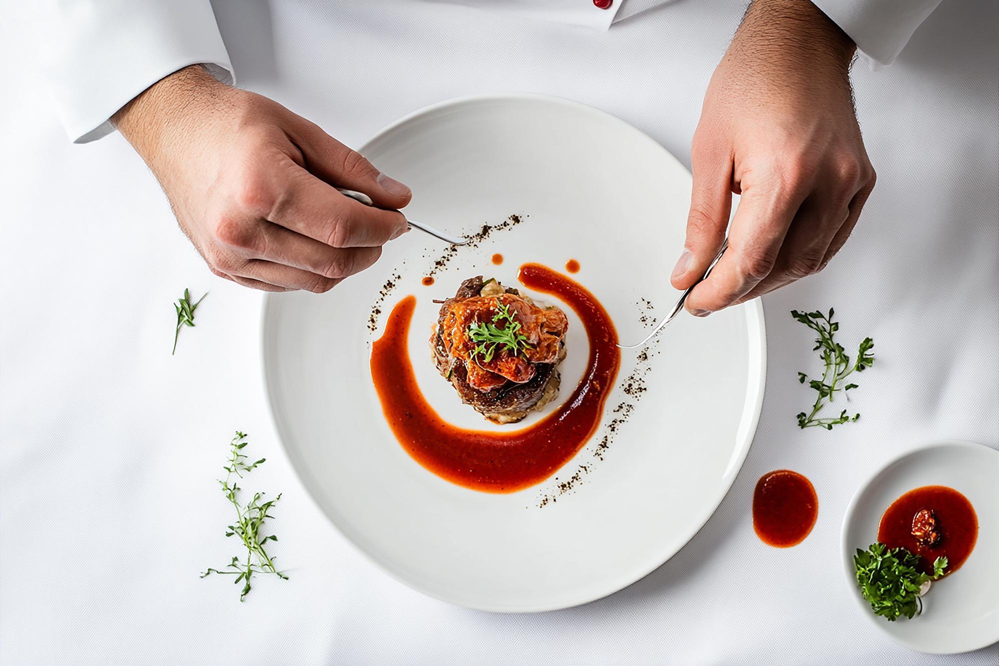 Large editorial shot of chefs plating dishes