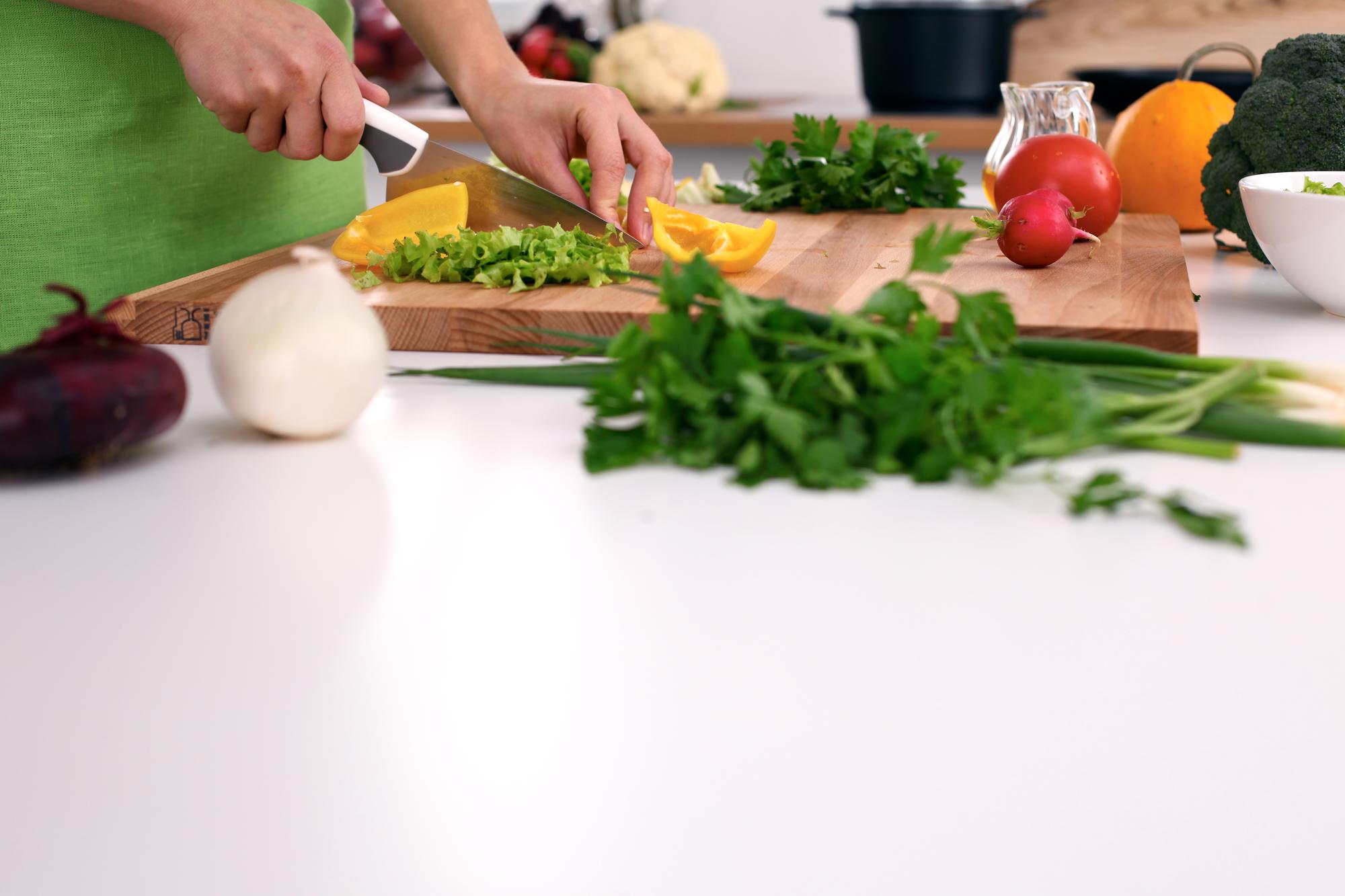 Participants chopping vegetables at wooden table